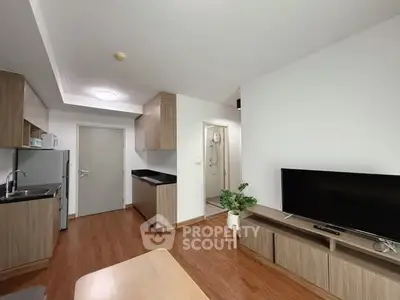 Modern open-plan living room with sleek kitchen and wooden flooring