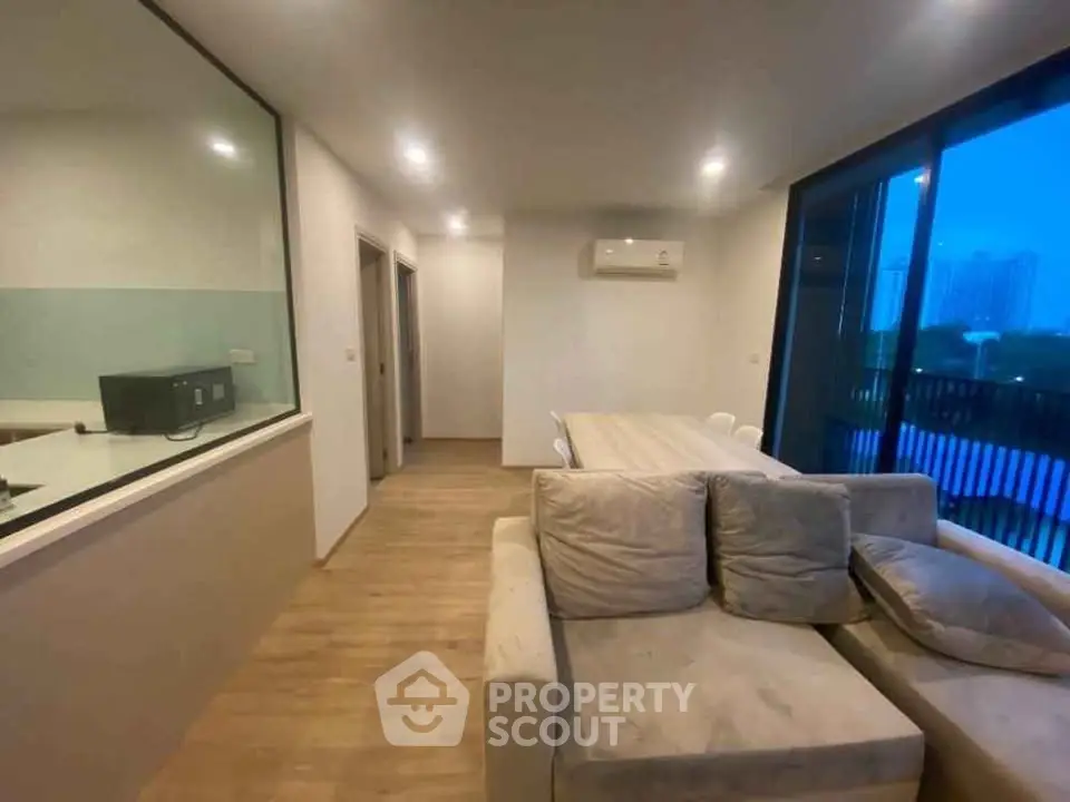 Spacious living room with modern decor and large windows offering a serene view.