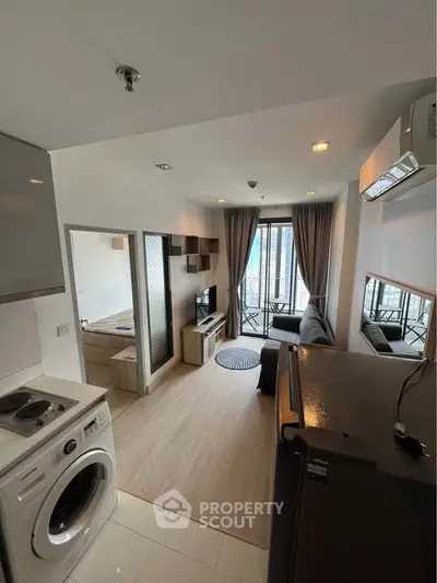Modern apartment interior with open layout, featuring a cozy living room and compact kitchen area.