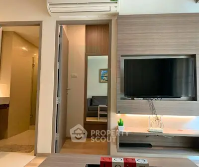 Modern living room with sleek TV setup and air conditioning, adjacent to a cozy bathroom.