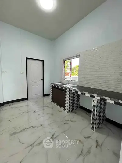 Modern kitchen with sleek tile design and ample natural light