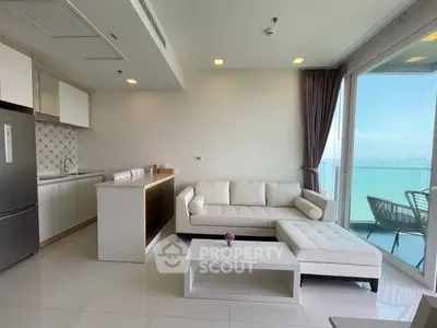 Modern living room with ocean view, sleek kitchen, and elegant furnishings.