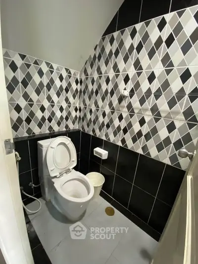 Modern bathroom with geometric tile design and sleek fixtures.