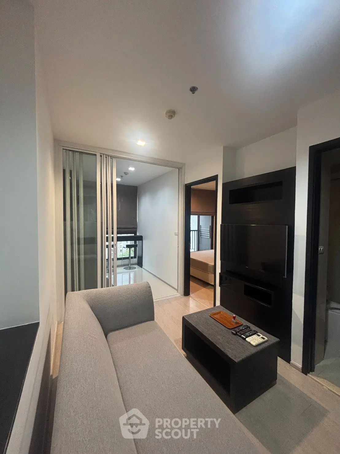 Modern living room with sleek furniture and open kitchen layout in a stylish apartment.