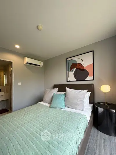 Modern bedroom with stylish decor and cozy ambiance, featuring a comfortable bed and contemporary artwork.