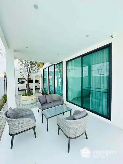 Modern outdoor patio with stylish furniture and glass sliding doors