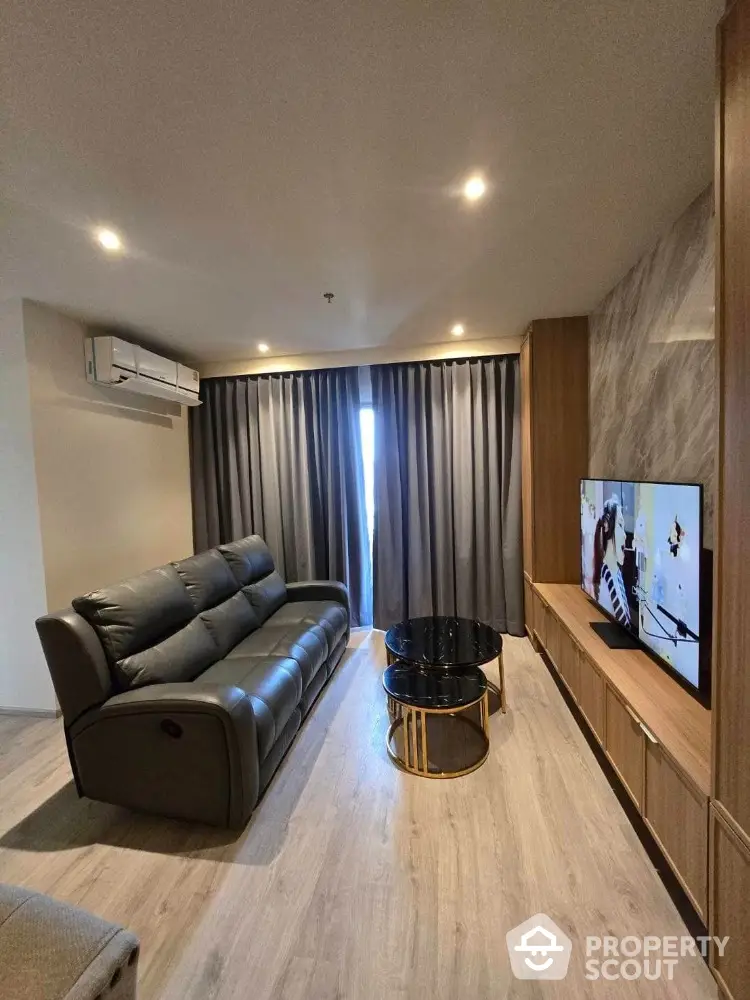 Modern living room with sleek furniture and large TV, perfect for relaxation.