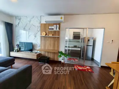 Modern living room with stylish wooden flooring and open kitchen layout