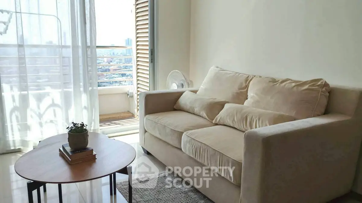 Cozy living room with beige sofa and balcony view in modern apartment