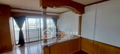 Spacious living room with wooden accents and balcony view