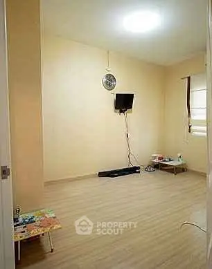 Minimalist living room with wall-mounted TV and wooden flooring