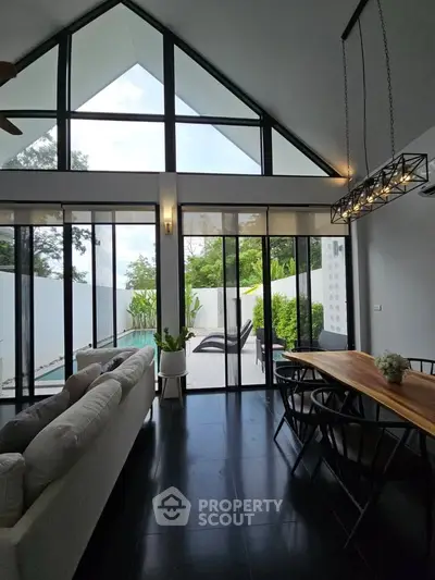 Stunning modern living room with high ceilings and pool view, perfect for luxury living.