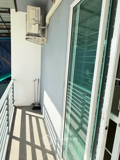 Charming balcony with sliding glass door and air conditioning unit, perfect for relaxation and fresh air.