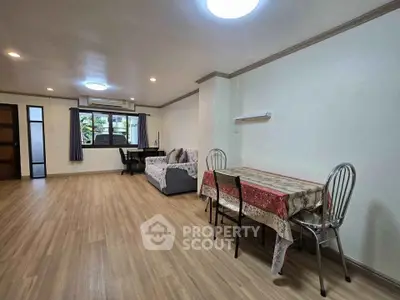 Spacious living room with modern decor and wooden flooring, perfect for family gatherings.