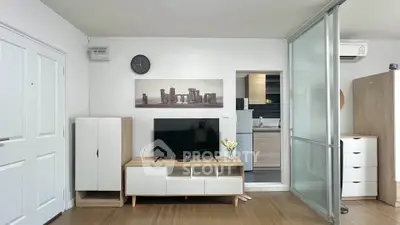 Modern living room with sleek TV stand and sliding glass door to kitchen