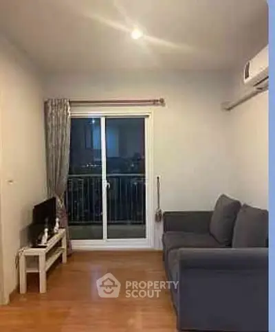 Cozy living room with balcony access and modern furnishings in a stylish apartment.