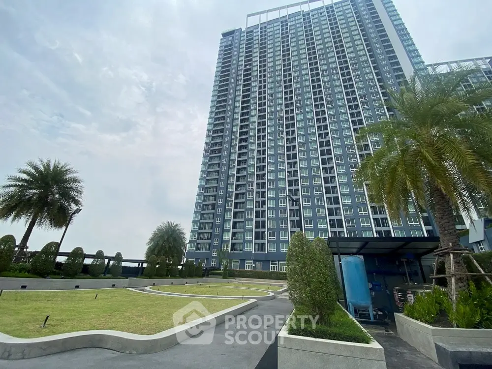 Modern high-rise building with landscaped garden and palm trees