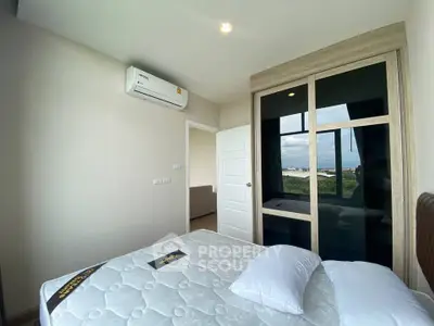 Modern bedroom with large window and built-in wardrobe offering scenic views.
