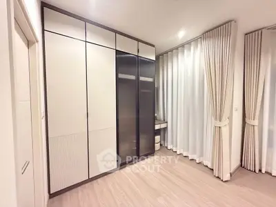 Spacious modern bedroom with elegant curtains and ample closet space