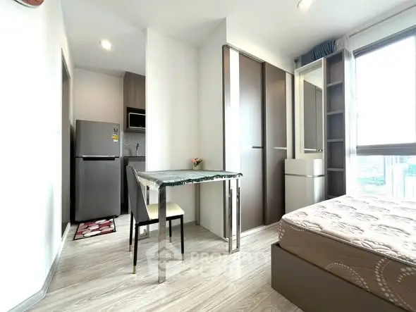 Modern studio apartment with sleek design, featuring a compact kitchen and cozy sleeping area.