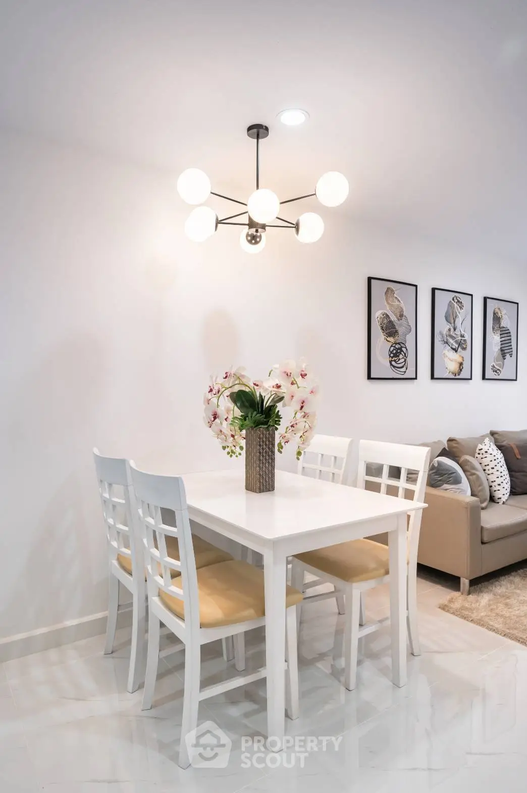 Elegant dining space with modern lighting and chic decor, complemented by a cozy living area, perfect for intimate gatherings.