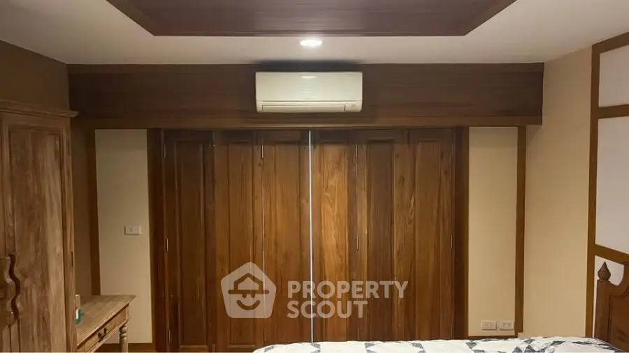 Cozy bedroom with wooden accents and air conditioning unit