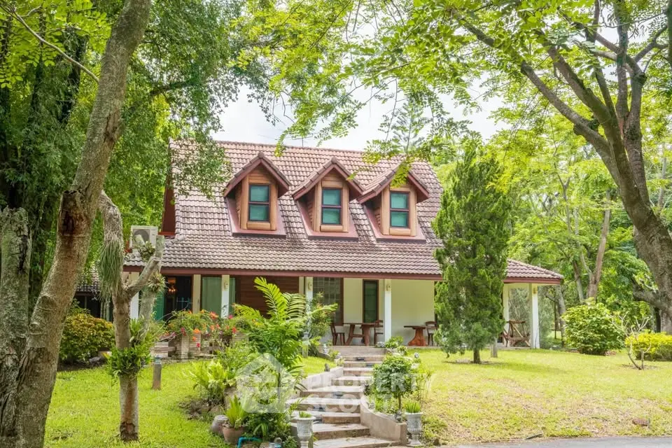 Charming countryside house with lush garden and inviting front porch.
