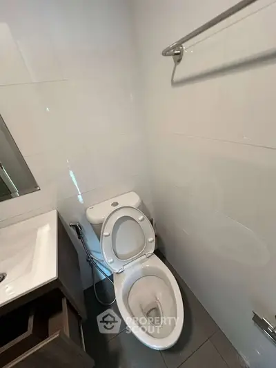 Modern bathroom with sleek fixtures and white tiles, featuring a compact design for efficient space use.