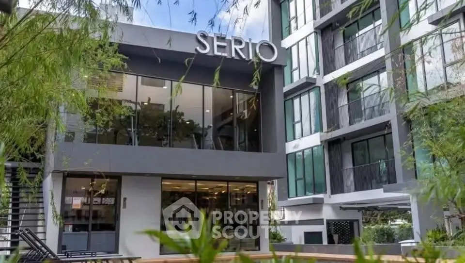 Modern apartment building exterior with sleek design and large windows in urban setting.