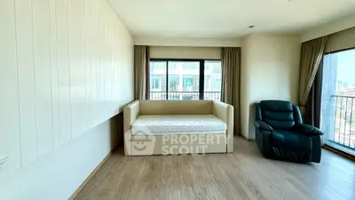 Spacious living room with large windows and modern furniture, offering a bright and airy atmosphere.
