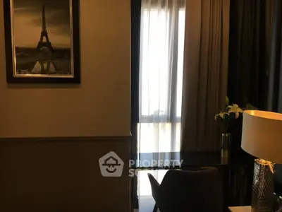 Elegant study area with desk, chair, and lamp near window with sheer curtains.