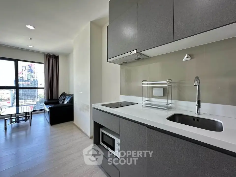 Modern open-layout kitchen with sleek cabinetry and integrated appliances in a stylish apartment.