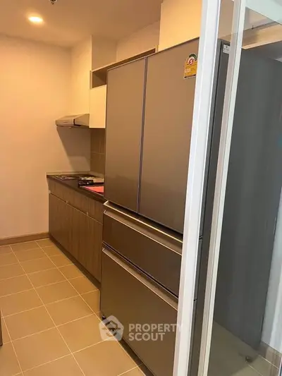 Modern kitchen with sleek appliances and closed layout in a contemporary apartment.