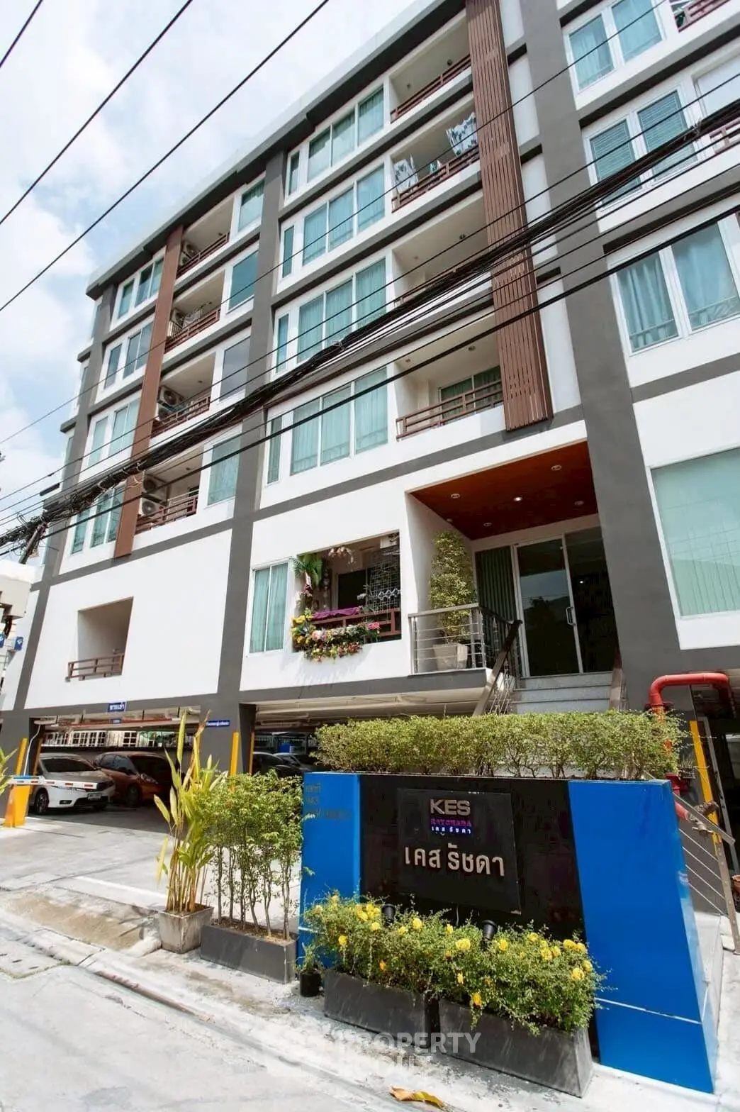 Modern multi-story residential building with sleek design and large windows in urban setting.