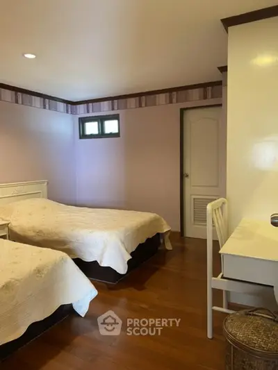 Cozy bedroom with twin beds and wooden flooring in a serene setting