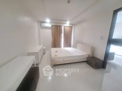 Spacious minimalist bedroom with modern furnishings and natural light