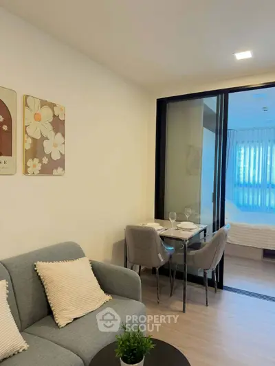 Modern living room with cozy seating and dining area, featuring elegant decor and natural light.