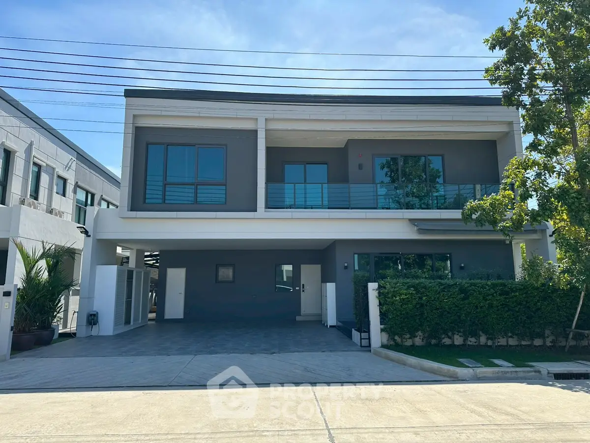 Modern two-story house with sleek design and spacious driveway in a serene neighborhood.