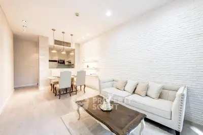 Elegant living room with stylish furniture and open kitchen layout in modern apartment.