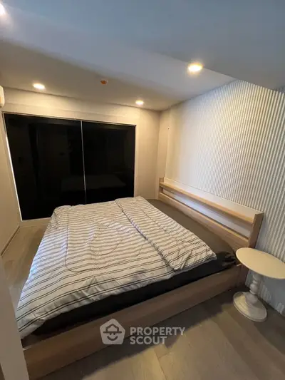 Modern bedroom with sleek design and cozy ambiance, featuring a comfortable bed and stylish lighting.