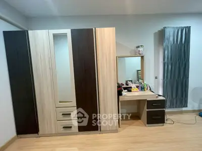Spacious bedroom with modern wardrobe and dressing table, perfect for stylish living.