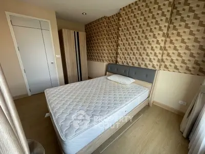 Modern bedroom with stylish geometric wallpaper and comfortable bed in a cozy apartment.