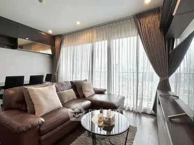 Spacious living room with elegant decor and large windows offering natural light.