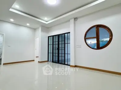 Modern minimalist interior with sleek glass doors and unique round window design.