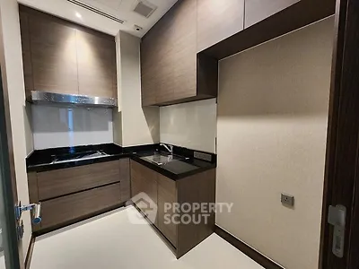 Modern kitchen with sleek cabinetry and black countertops in a luxury apartment.