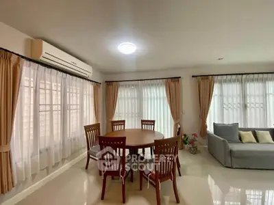Spacious living room with elegant dining set and cozy sofa, perfect for family gatherings.