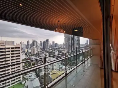 Stunning cityscape view from a spacious high-rise balcony with elegant lighting and modern glass railing.