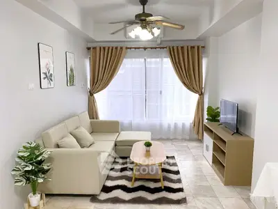 Modern living room with beige sofa, stylish decor, and natural light.