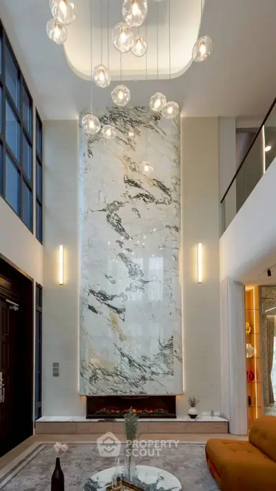 Luxurious living room with high ceilings, marble fireplace, and modern lighting