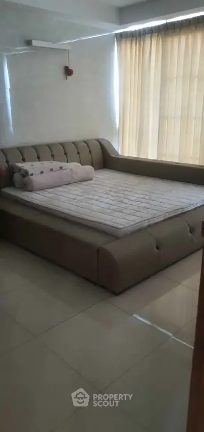 Spacious bedroom with elegant bed and natural light through blinds